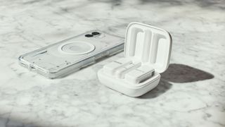 Rode Wireless Micro microphones in white next to an iPhone on a marble surface