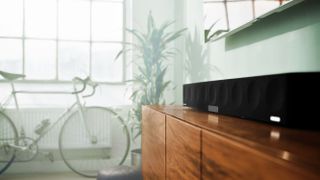 living room with bike, plant and a Sennheiser soundbar on top of a sideboard