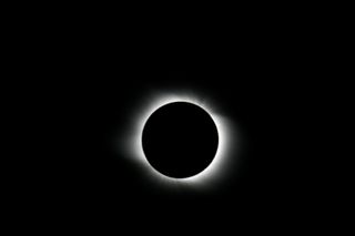 A view of the totally eclipsed sun, which makes the sun's atmosphere visible to the naked eye.
