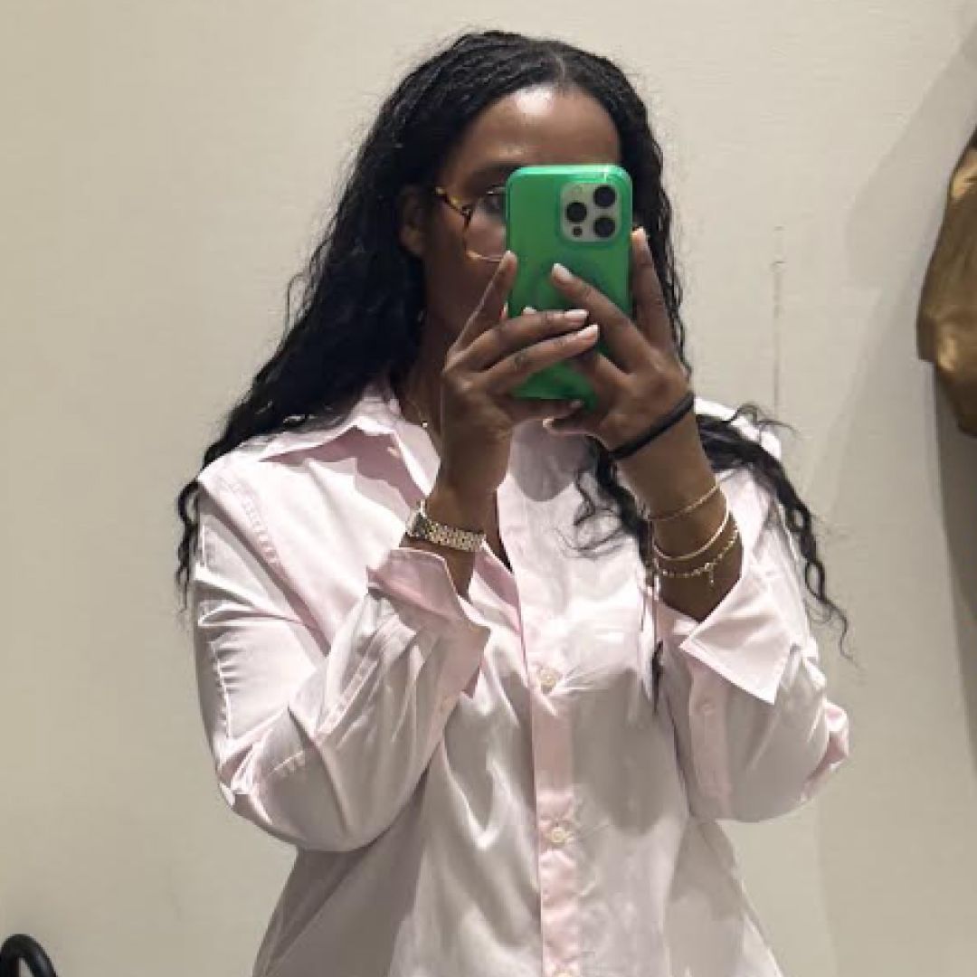Tariro Makoni wearing a pink shirt in a mirror selfie