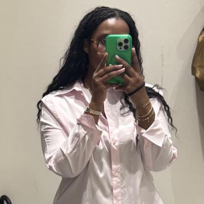 Tariro Makoni wearing a pink shirt in a mirror selfie