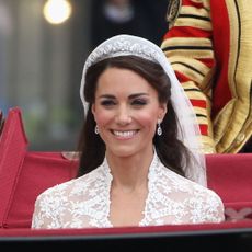 Kate Middleton smiling in a carriage on her wedding day to Prince William in April 2011