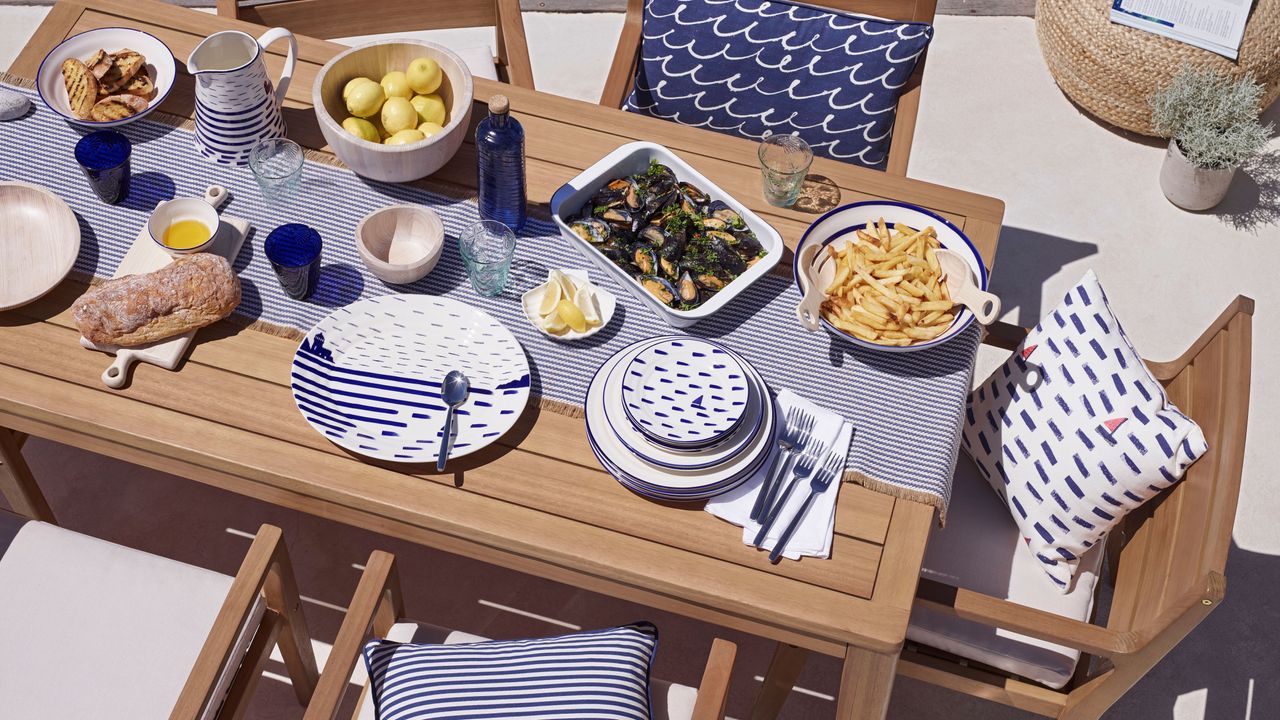 wooden table with blue throw and tablke scheme for outdoor dining