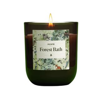 The Jackfir Forest Bath Candle in a small jar with green signage