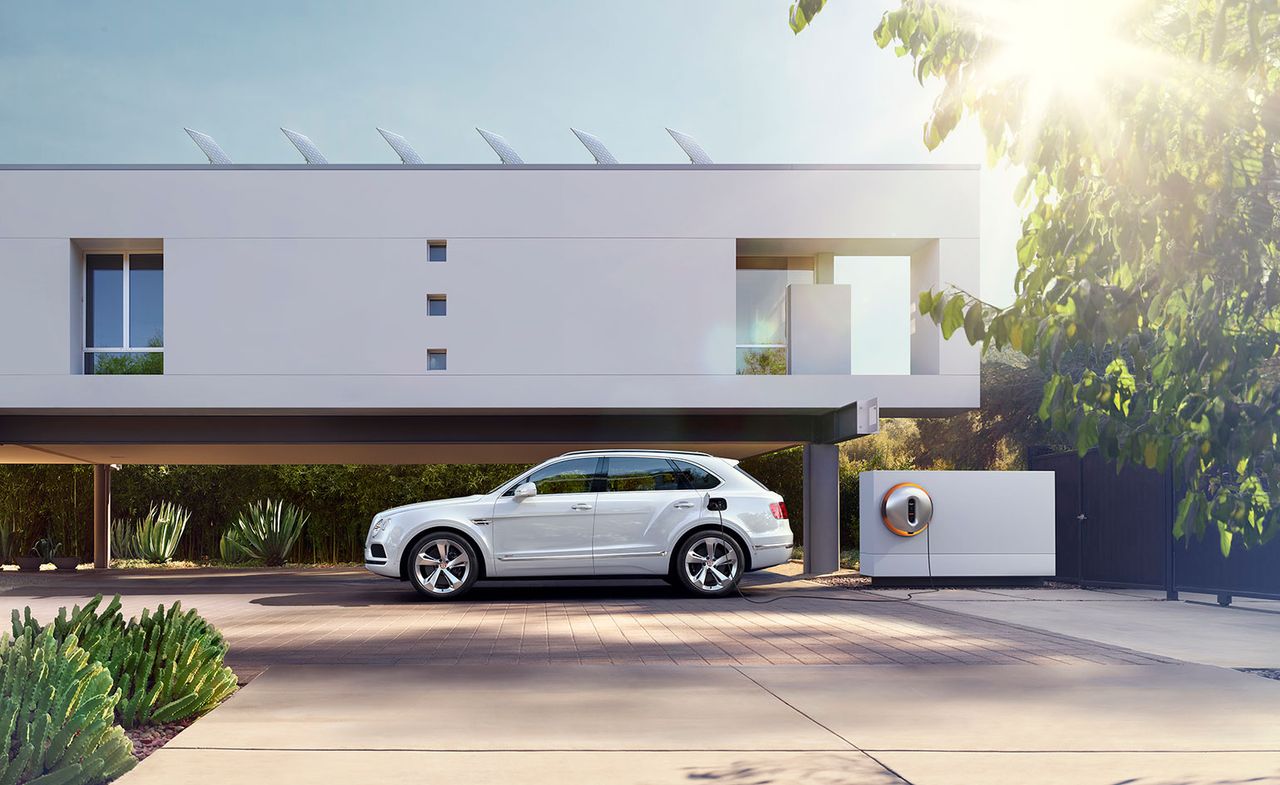 White Bentley car parked on a driveway plugged into a charger