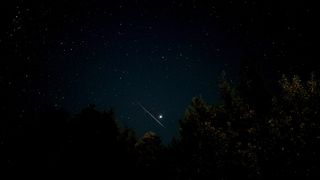 perseid meteor streaking across sky just under Jupiter shining brightly