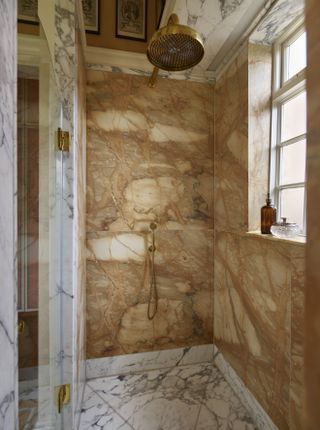 Amber colored marble shower alcove with waterfall showerhead