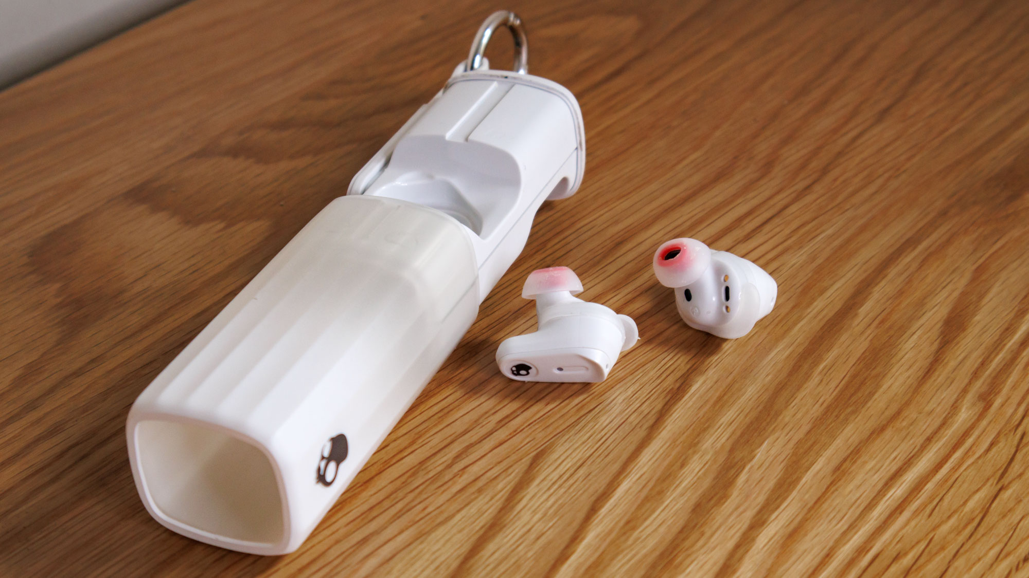 Skullcandy Method 360 ANC earbuds on a wooden surface