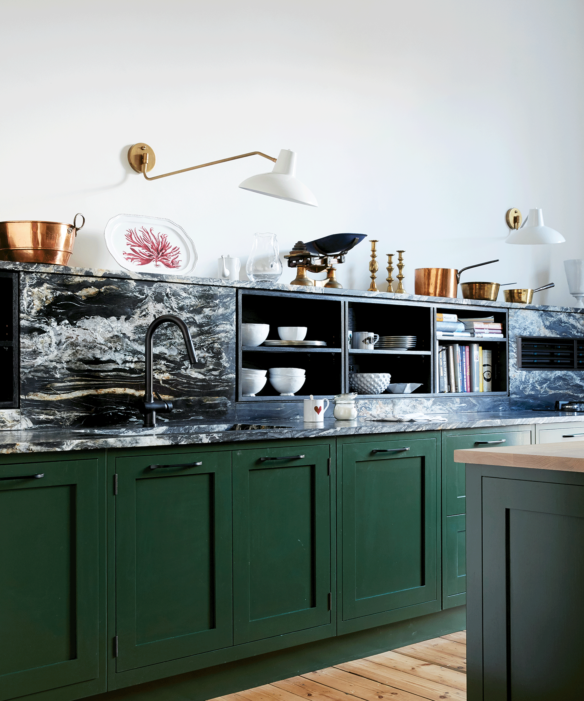 Green kitchen with marble worktop and splashback which incorporates storage