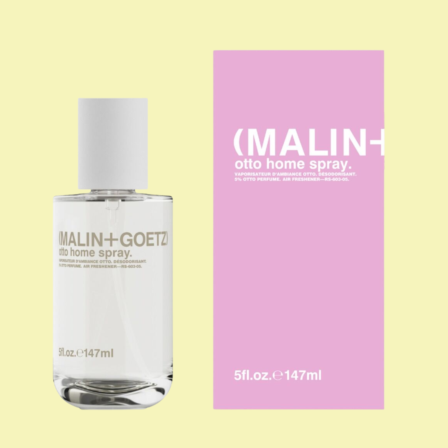 A glass room spray bottle beside a pink box