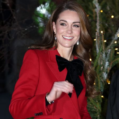 Princess Kate arrives at the annual Together at Christmas carol service wearing a red coat with a bow fastened at the collar