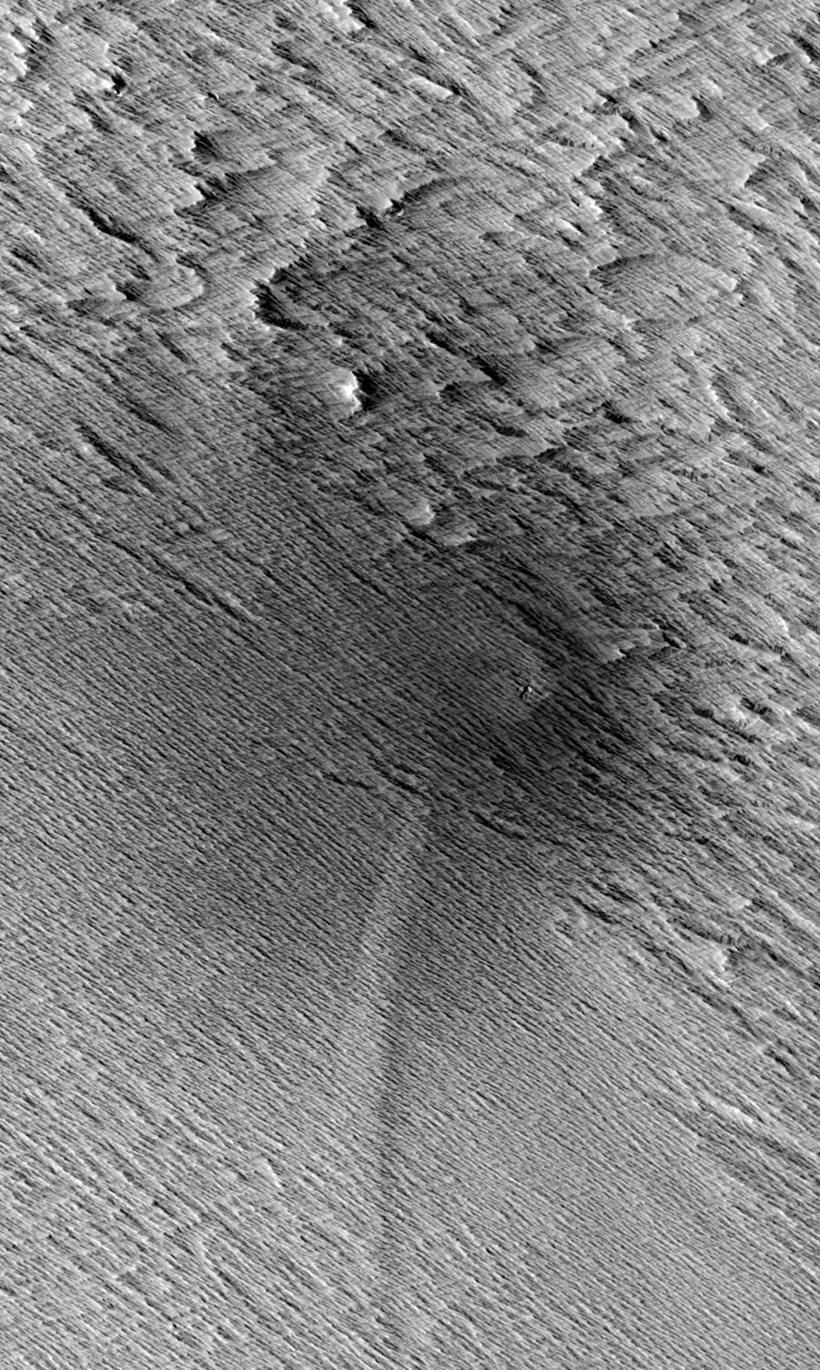 This HiRISE image from NASA&#039;s Mars Reconnaissance Orbiter shows a central crater on Mars with two dagger-like features extending at an angle. Called scimitars, these features most likely resulted from shockwave interference just before impact, scientists 