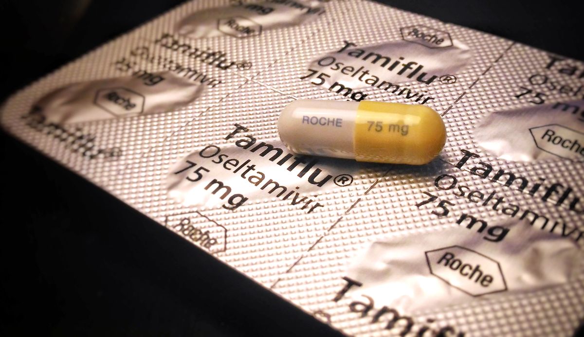 A single Tamiflu capsule sits outside its packaging.