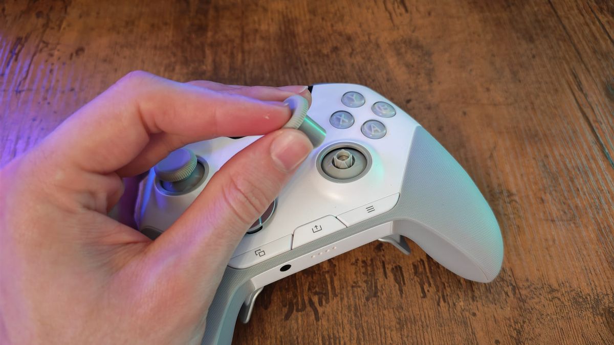A reviewer removing a thumbstick top for the SteelSeries Aeon Pro