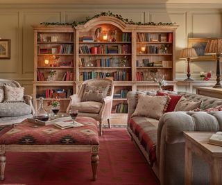 traditional english living room with a pink color scheme and last antique bookcase decorated for christmas