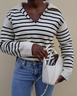 Aida wears a striped Breton jumper with jeans and a mini bag.