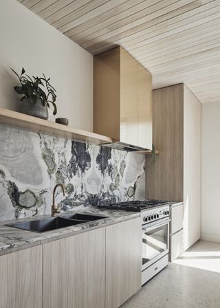 A kitchen remodel with grey marbled backsplash