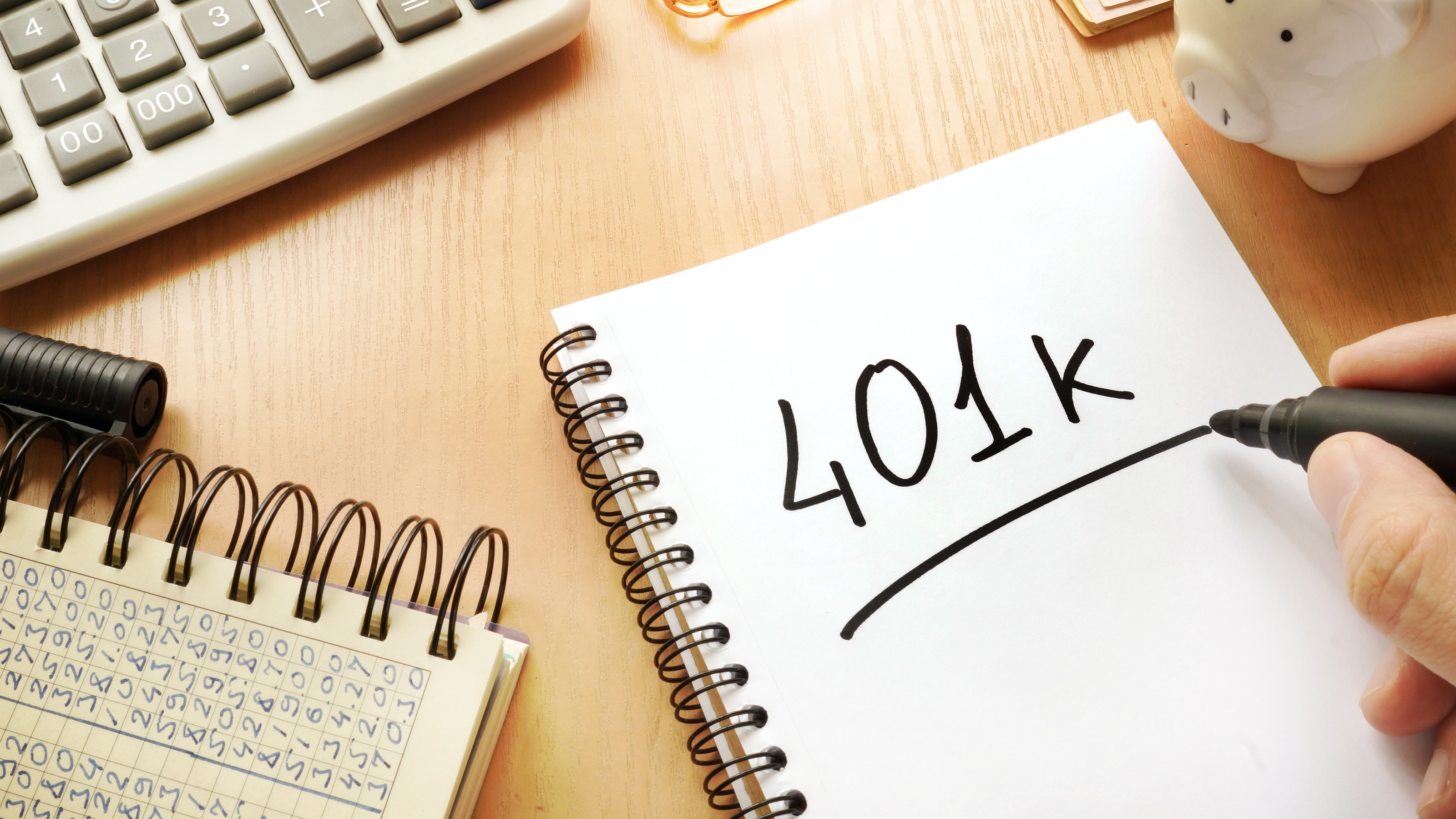 401k written on a spiral notebook on a desk.