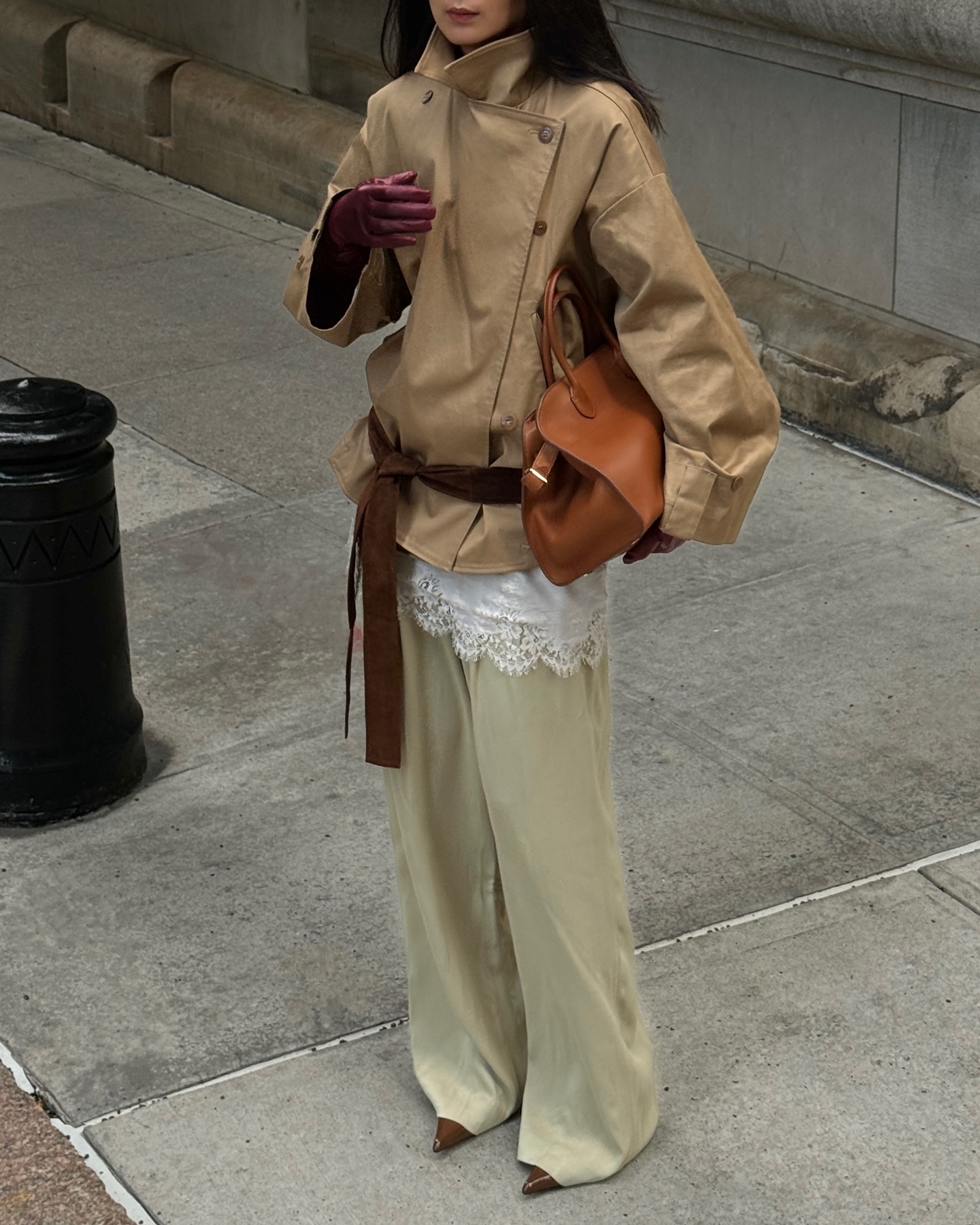 An image of @thecarolinelin wearing a lace trim blouse with satin trousers and a funnel-neck leather jacket.