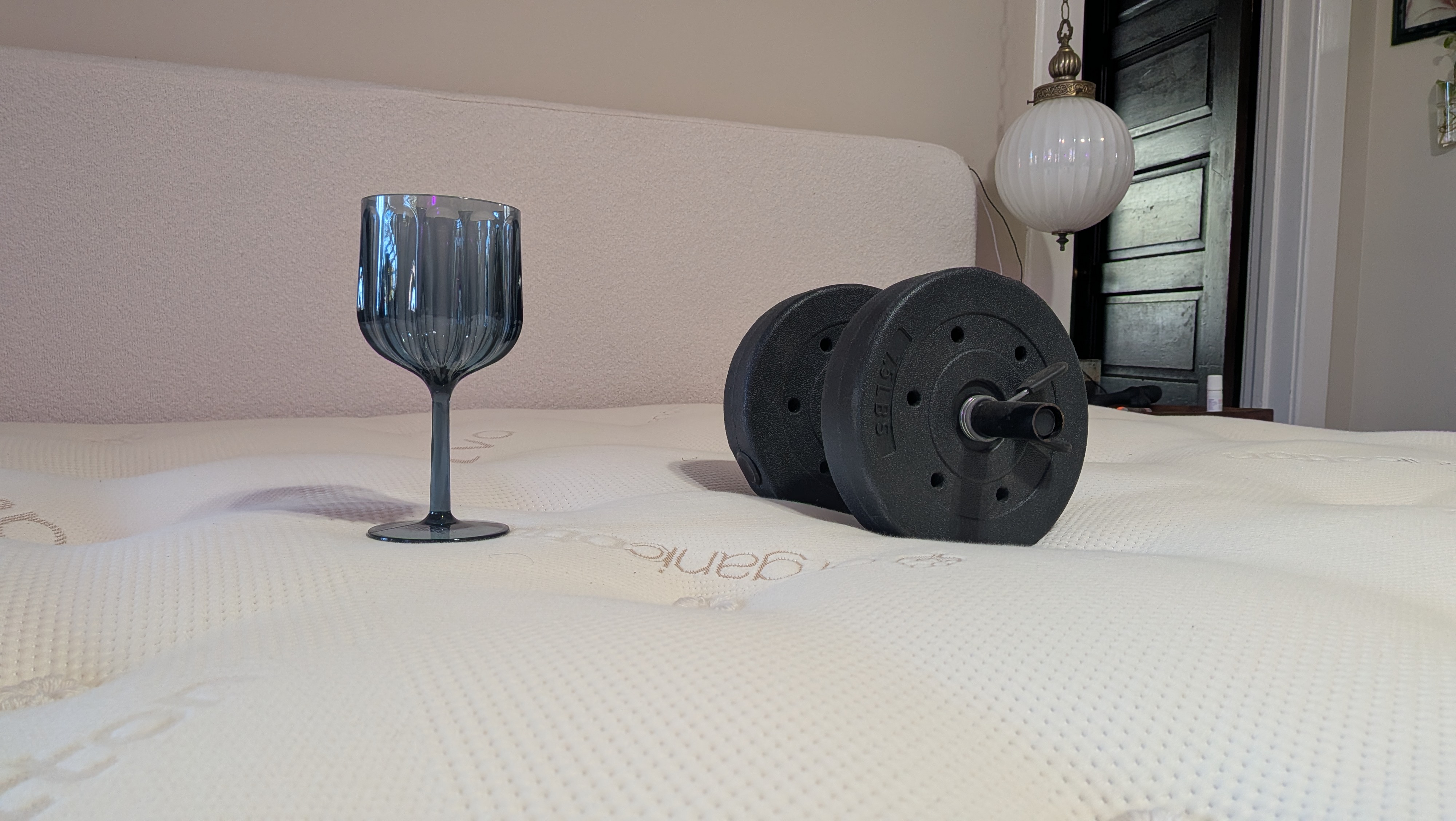 Testing the motion isolation of the Saatva Latex Hybrid Mattress using aa 15lb dumbbell and an empty wine glass