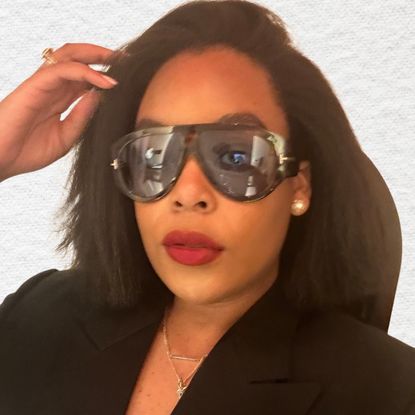 Ariel Baker's headshot. She is wearing red lipstick and sunglasses. 