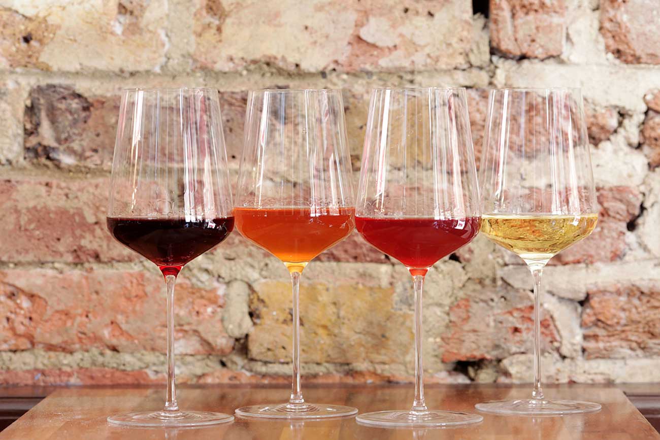 A row of wine glasses against a brick wall
