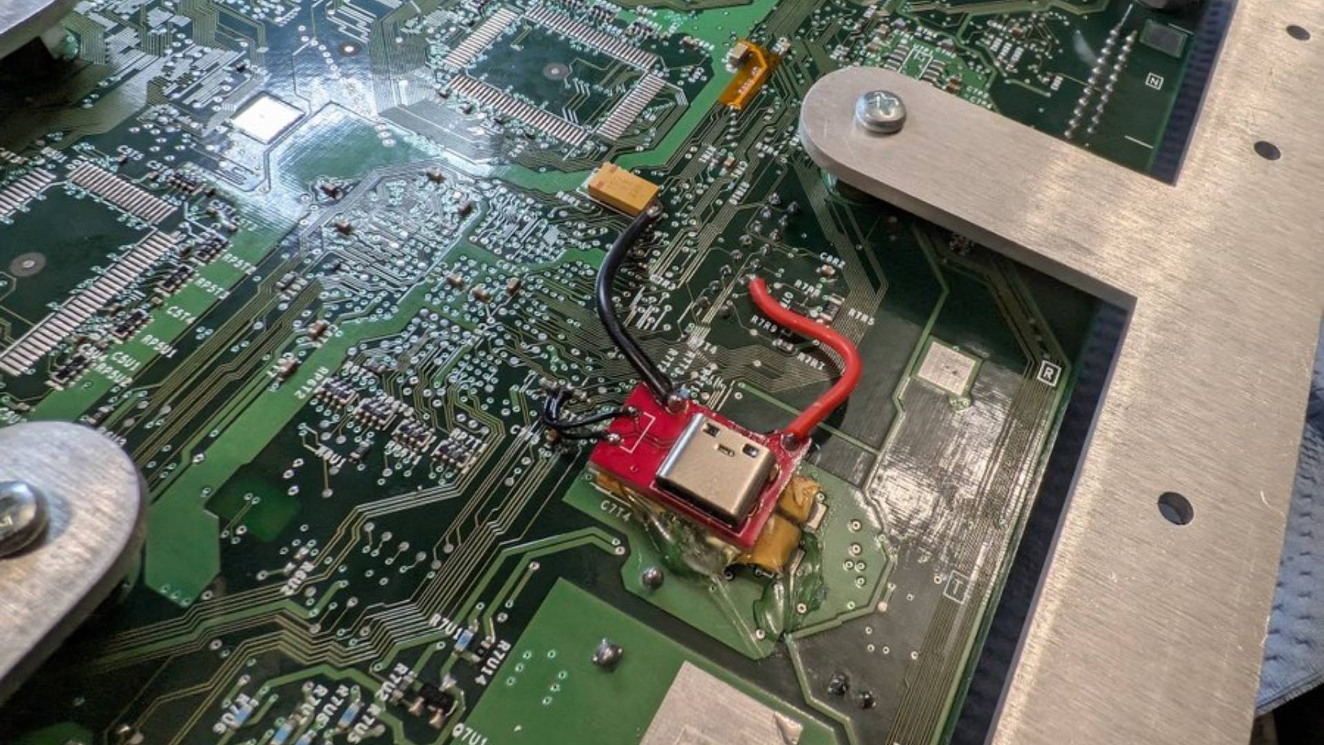 Close up of hidden USB port in original Xbox with connector fitted and wires soldered to board points.