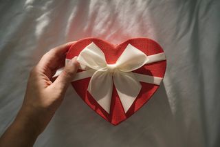 A red heart-shaped box with a white bow.