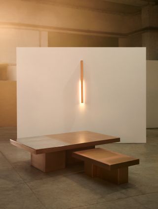 Vertical lamp on wall and two sized wooden coffee tables