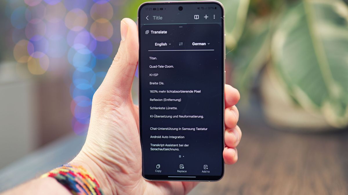 Samsung Galaxy S24 phone held in a hand with the screen showing text on a black background