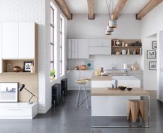 A large white modern kitchen in a beamed space with kitchen island