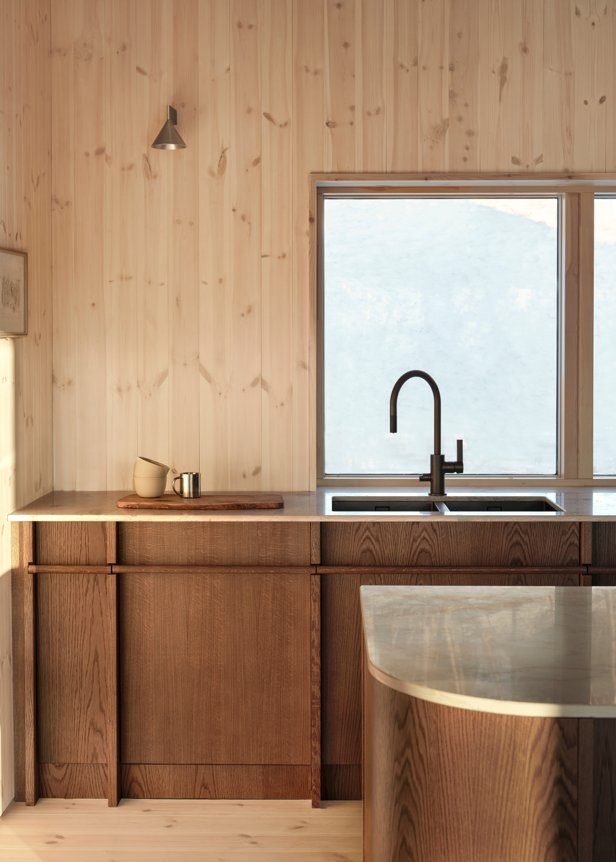 wooden cabin kitchen with light wooden walls, dark oak cabinets, and steel counters