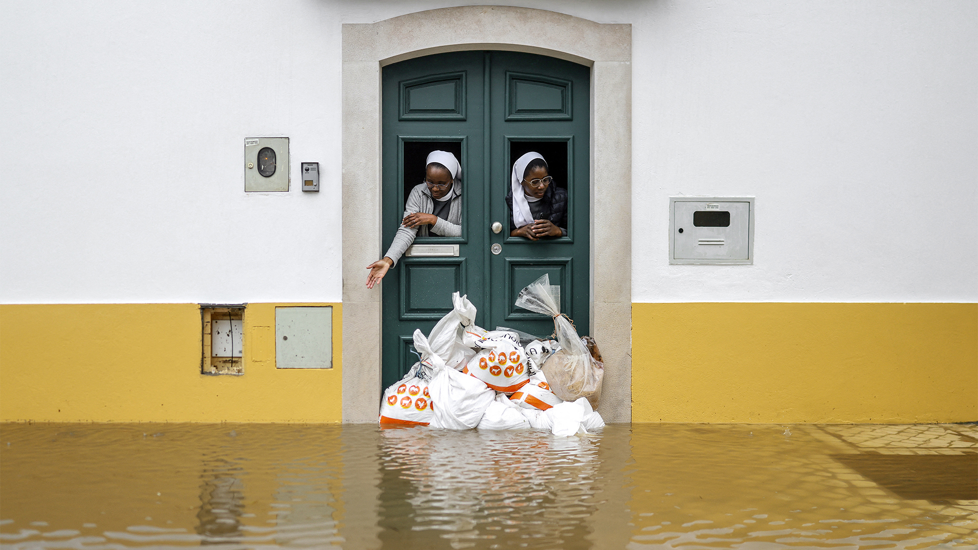 Two nuns examine the floodwaters left behind by Storm Leonardo in Alcácer do Sal, Portugal