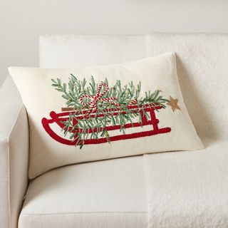 Christmas Tree Sled Embroidered Lumbar Pillow on a white sofa.