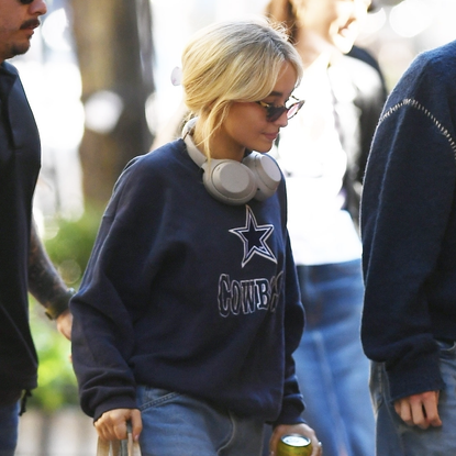 Sabrina Carpenter keeps a low profile in a navy blue oversized "Cowboys" sweatshirt, knee-length denim shorts, and black knee-high boots as she grabs lunch at Buvette French restaurant in New York. Oct 10