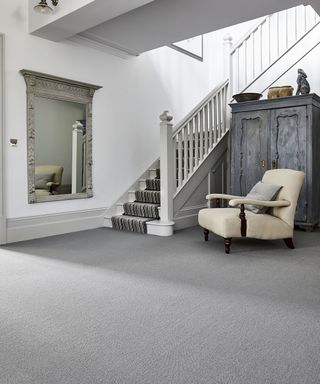 Grey hallway ideas by Carpetright with ornate framed mirror and cream armchair