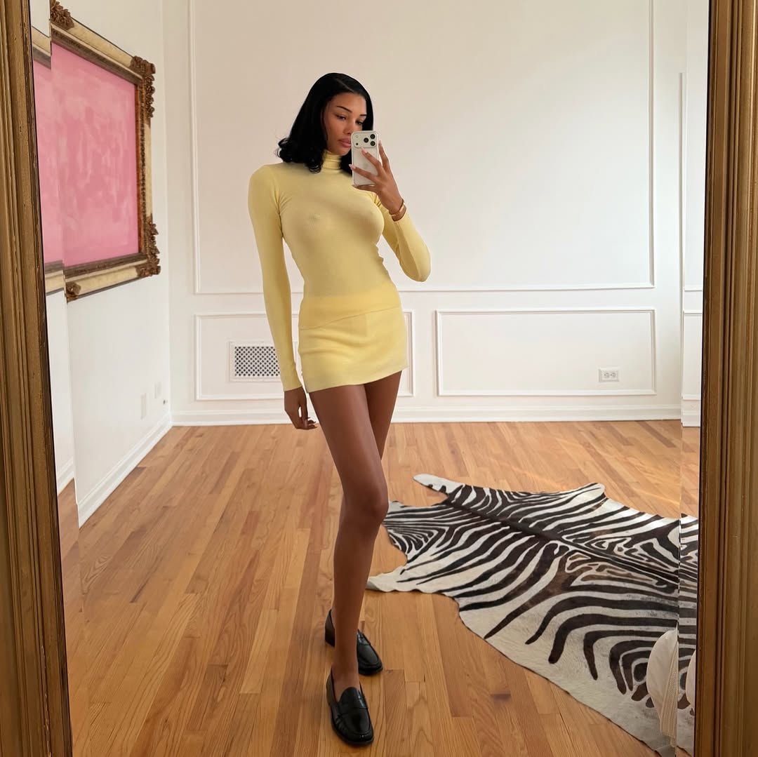 A woman wearing thin knit and miniskirt, one of the biggest 2026 spring to summer transitional trends.