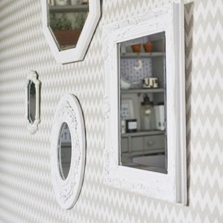 white wallpaper with white framed mirrors