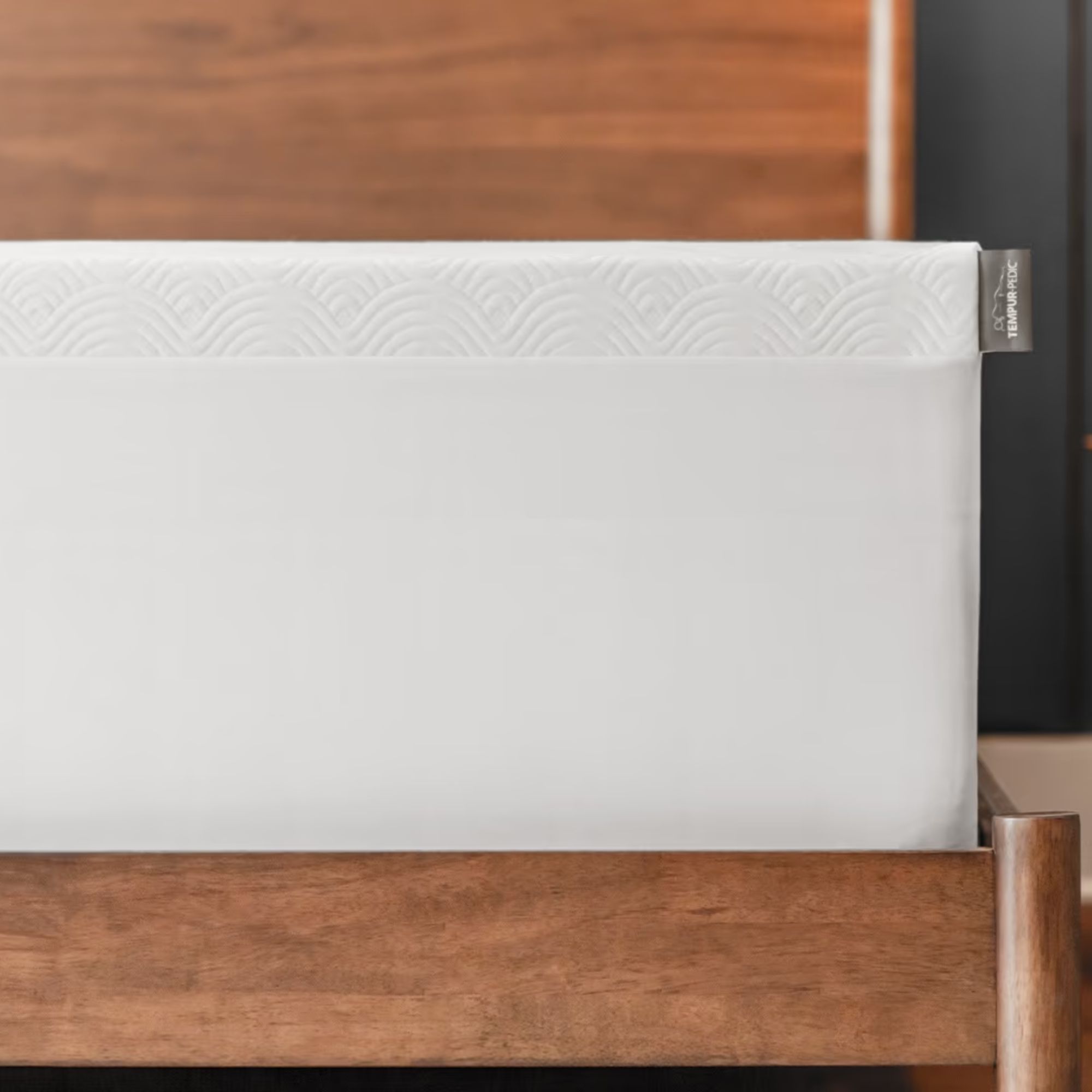 A white Tempur-Pedic Cloud topper on a white mattress and wooden bedframe