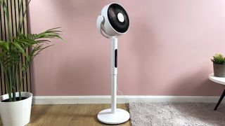 The Levoit CirculAir is at its full height in the middle of a pink living room.