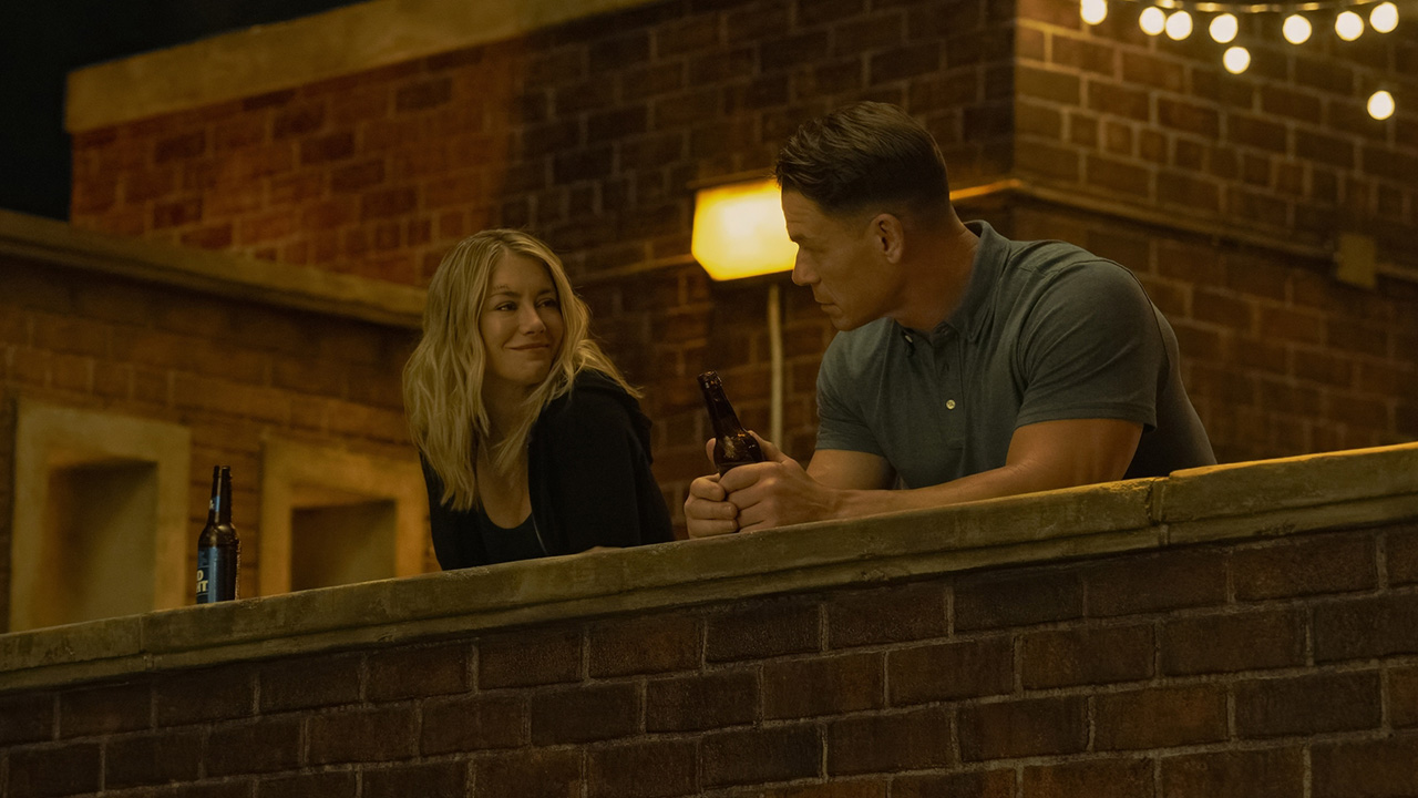 Emilia Harcourt smiling at Chris Smith at night in Peacemaker season 2