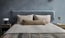 cool blue bedroom with limewash walls, velvet headboard and neutral linen
