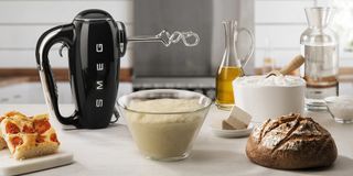 Image of Smeg Retro 1950s hand mixer in lifestyle image being used to make bread