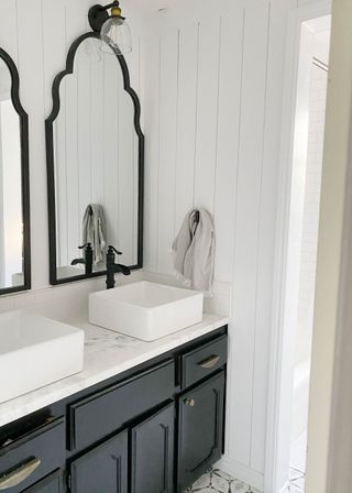 Painted bathroom with black trim mirrors, black painted vanities and white sinks