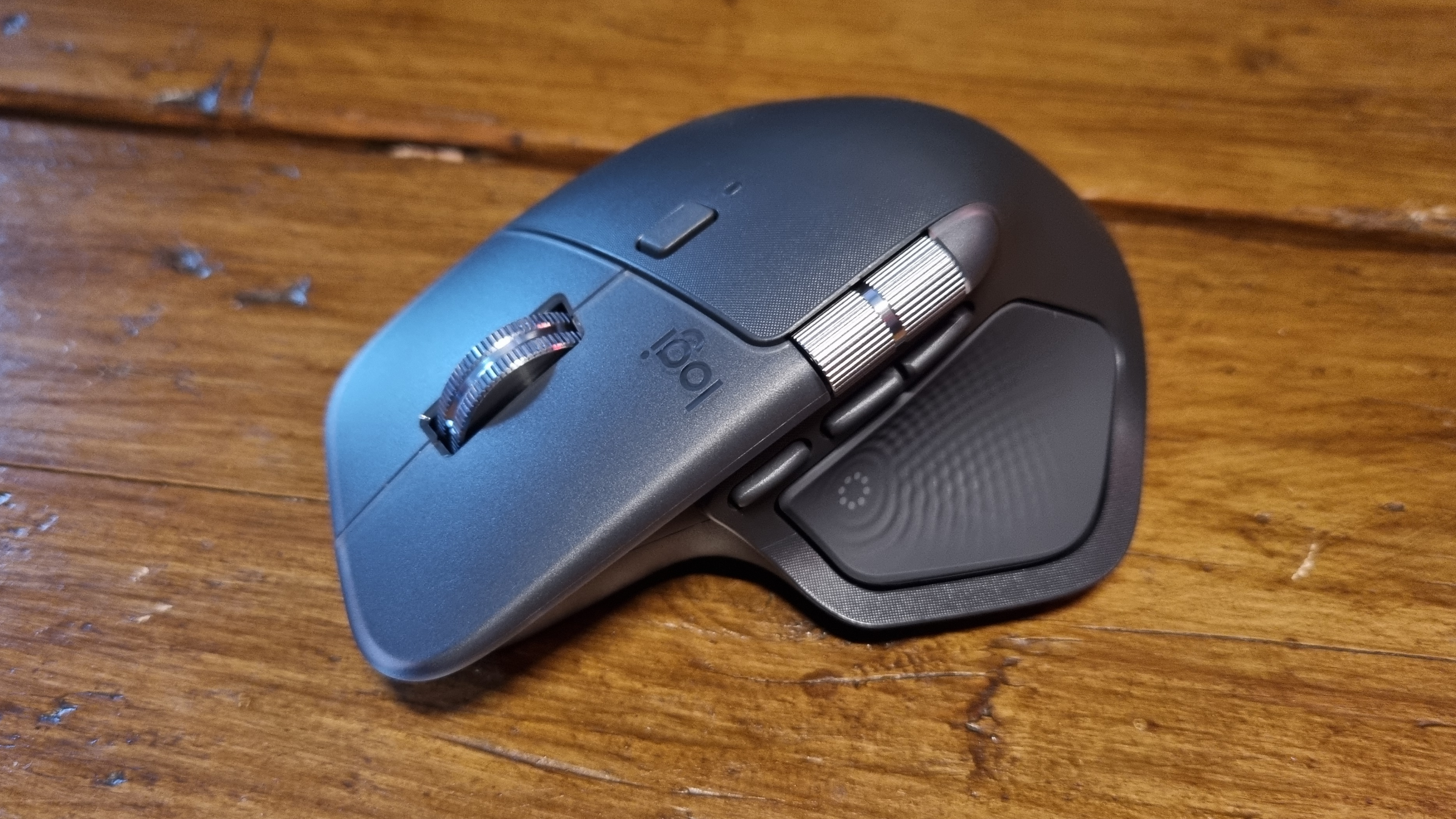The Logitech MX Master 4 productivity mouse on a wooden desk