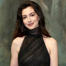 Anne Hathaway arrived at the Ralph Lauren Fall 2026 show in a sheer halter-neck dress and a feather boa