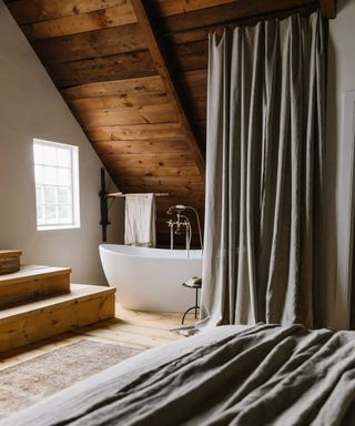 A bathtub in a room with wooden vaulted ceilings