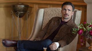 Juan Pablo Raba as Joaquin in Dutton Ranch, episode 8, season 1. He's sitting in a chair and leaning on the right armrest. 
