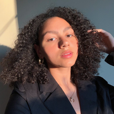 Girl with curly hair and glowy skin.