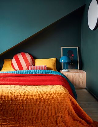 Dark bedroom with grey walls and colorful bedding